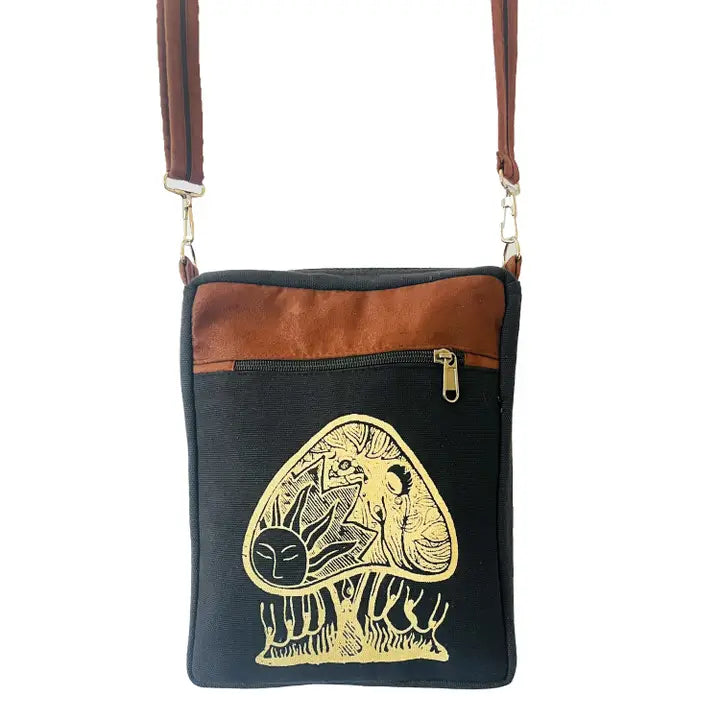 A stylish black and brown crossbody bag featuring a gold mushroom design with illustrations inside the design