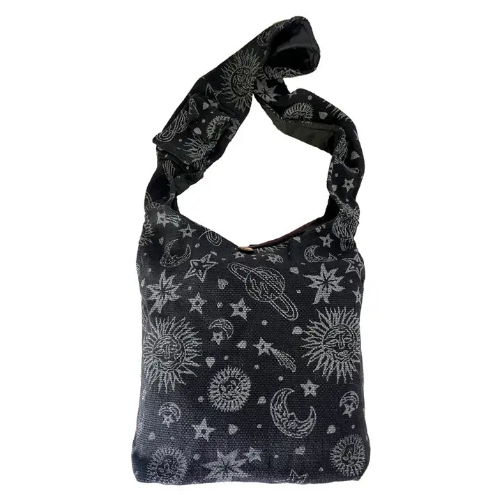 A dark grey crossbody bag featuring a light grey celestial print of stars, suns, moons, and planets